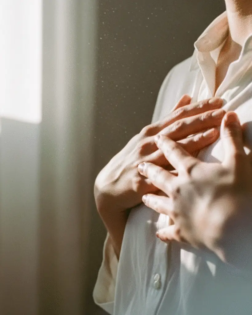 Persoană ținându-și mâinile pe piept, în lumină blândă