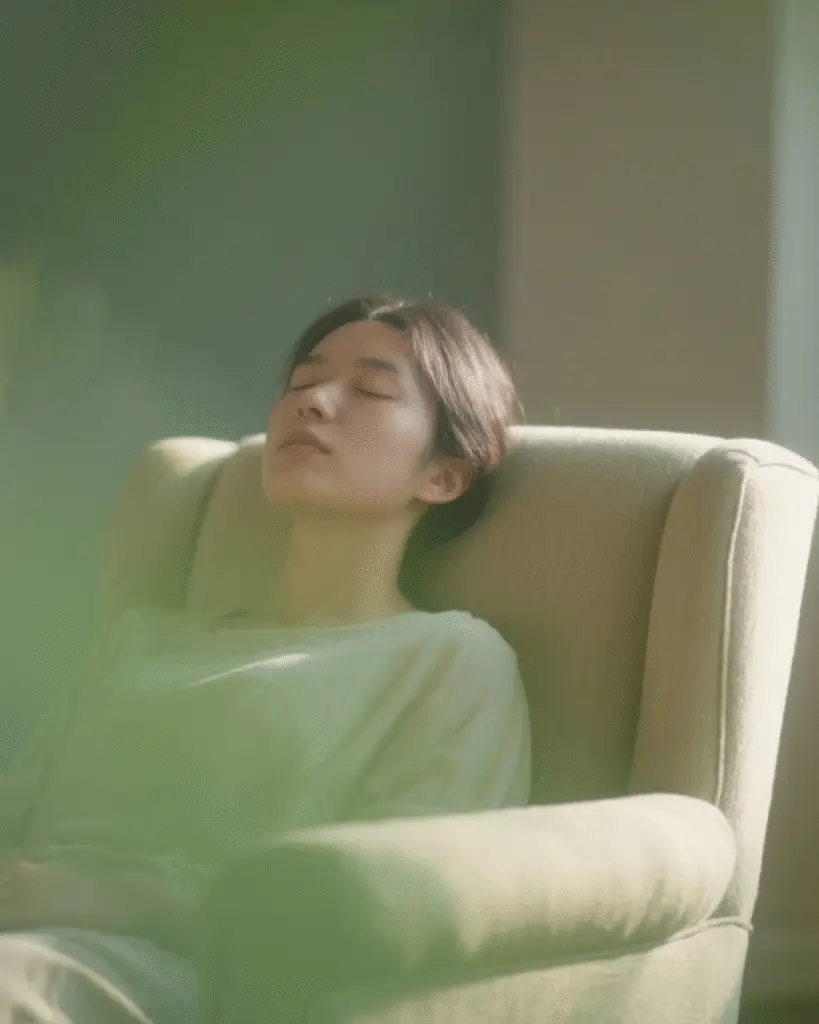 Femeie relaxată pe un fotoliu în lumina naturală.