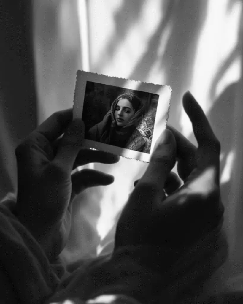 Fotografie veche ținută în mâini, portret în alb-negru.